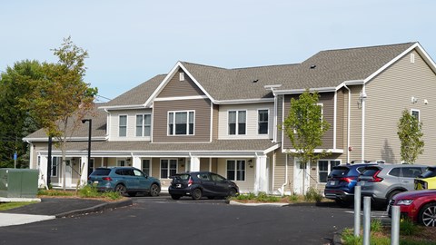 A large two-story building with a parking lot in front.