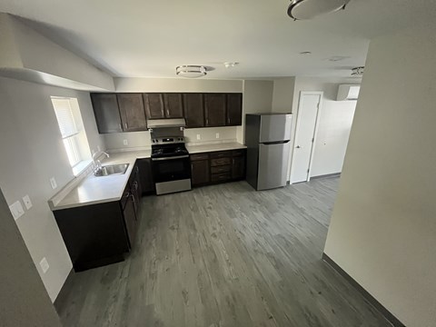 A kitchen with a black counter top and a white fridge.