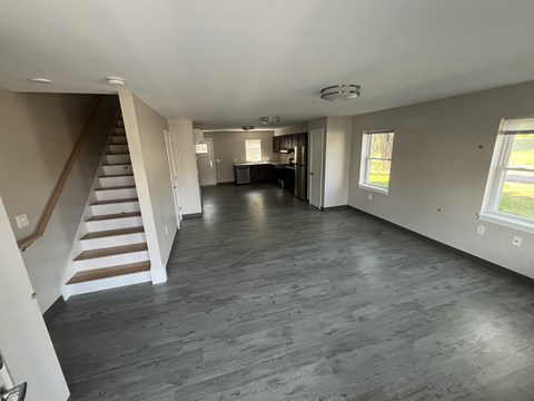 A spacious room with a staircase and a dining area.