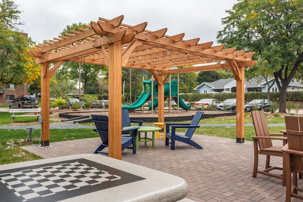 a picnic area with a chess board and a swing set in a park