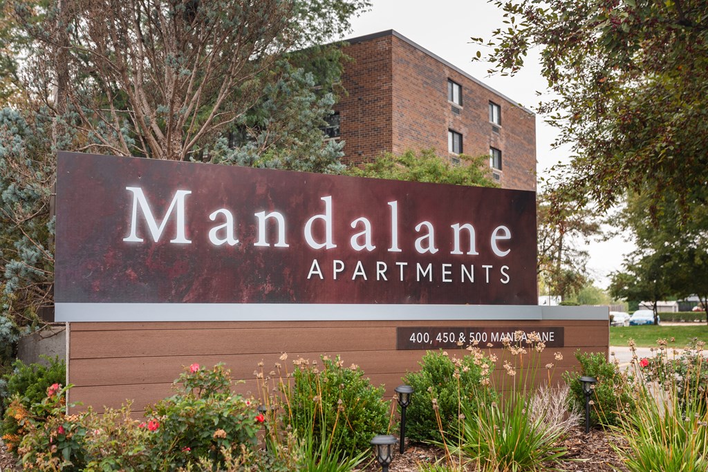 a sign for mandalane apartments in front of a building