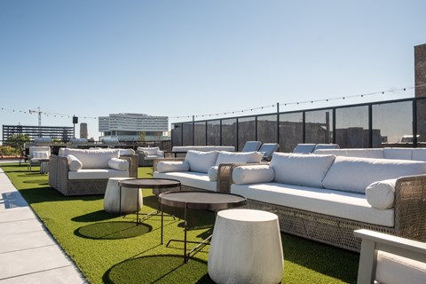 A sunny day at the outdoor seating area with white couches and tables.
