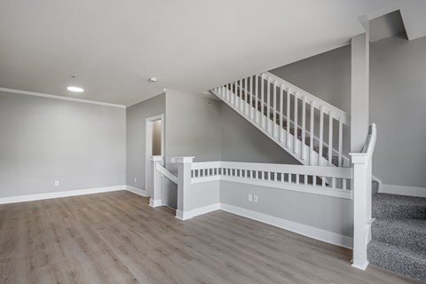 A spacious room with a staircase leading to the upper level.