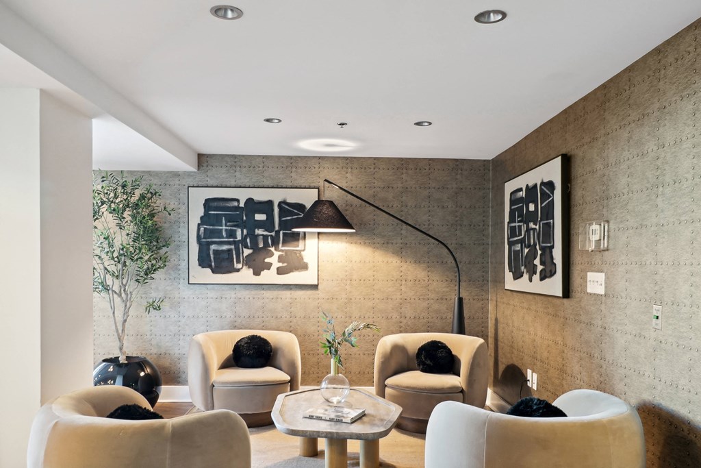 a living room with a bunch of chairs and a table and a wall with artwork at The Zenith, Baltimore
