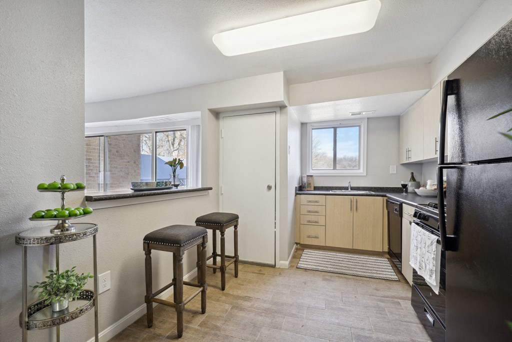 a kitchen with a refrigerator and a counter with three stools at Capitol Heights, Capitol Heights, MD, 20743