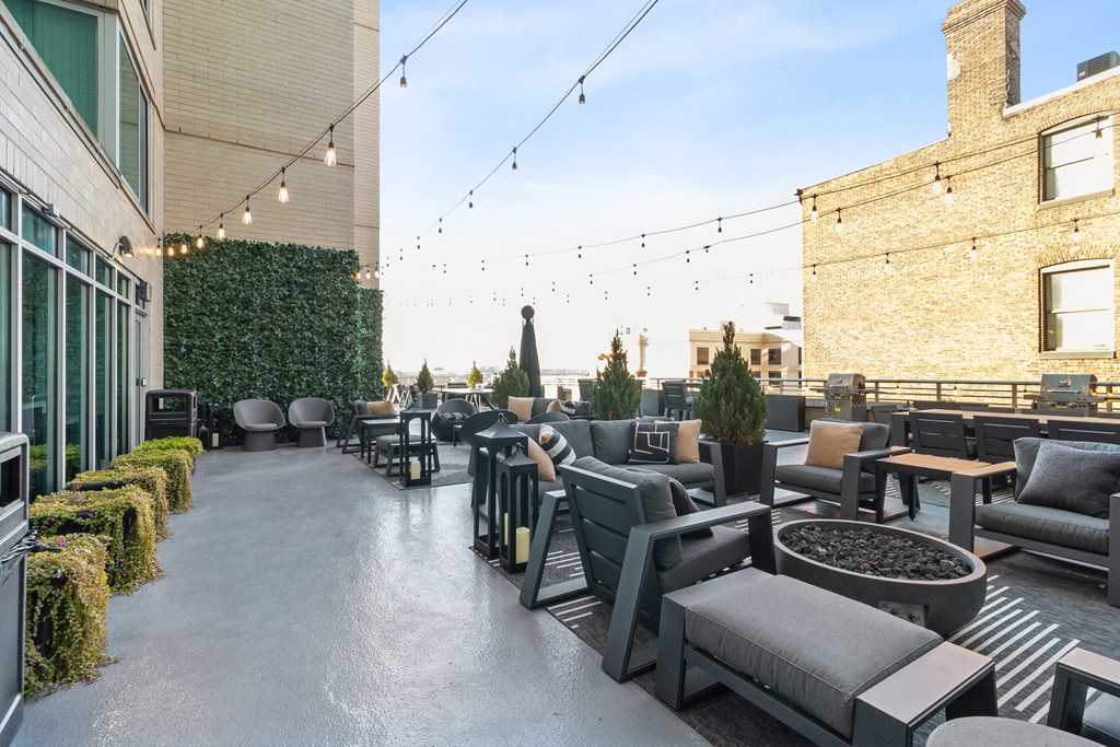 a rooftop patio with chairs and tables and a fire pit at The Zenith, Maryland