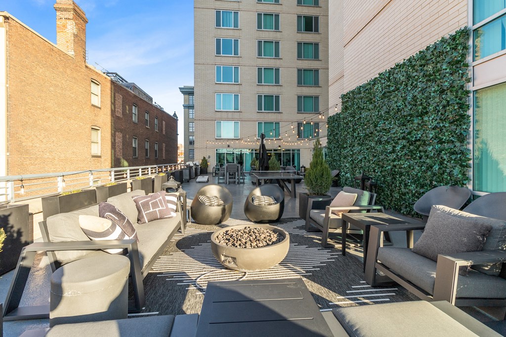 a rooftop patio with couches and chairs and a fire pit at The Zenith, Baltimore, MD