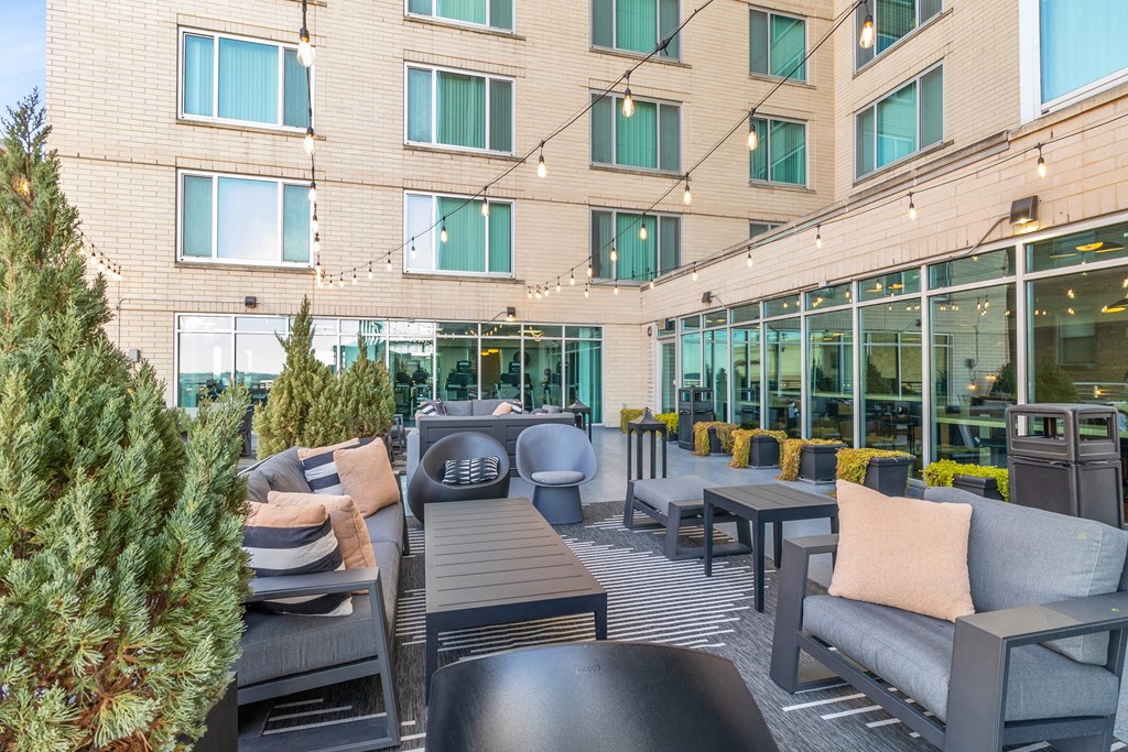 an outdoor patio with chairs and tables and a building in the background at The Zenith, Baltimore, MD