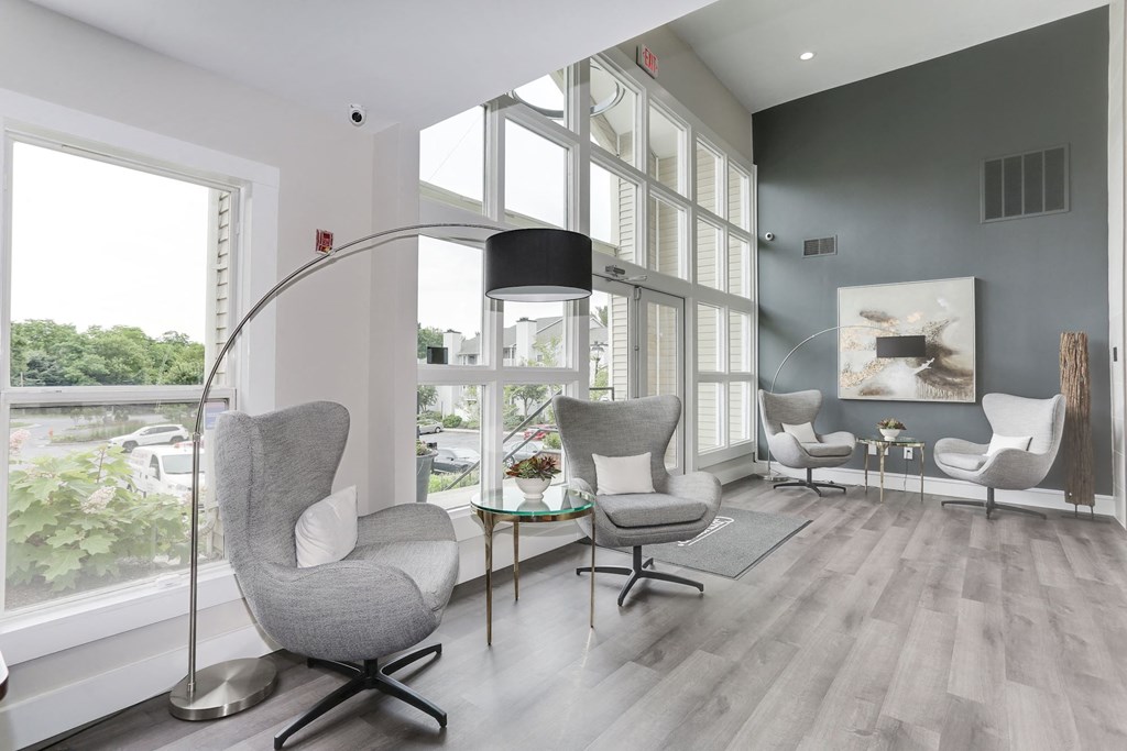 a living room with gray chairs and a floor lamp at Madison at Eden Brook, Columbia, MD 21046