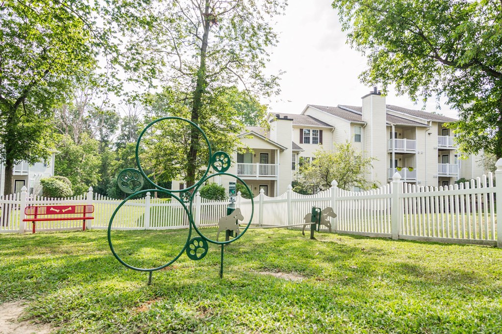 a park with a bench and a fence in front of an apartment building at Hamilton at Kings Place, Columbia City