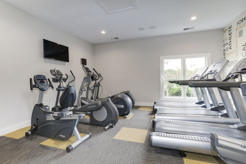 a gym with cardio equipment and a flat screen tv at Madison at Eden Brook, Maryland