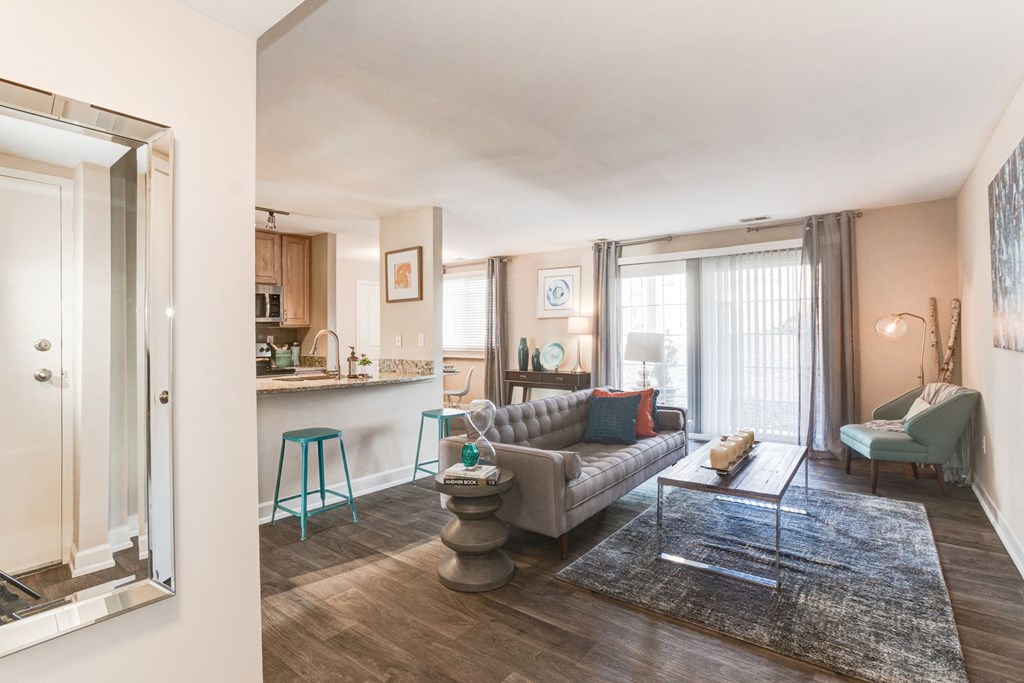 a living room with a couch a table and a chair and a kitchen in the background at Ellicott Grove, Ellicott City, 21043