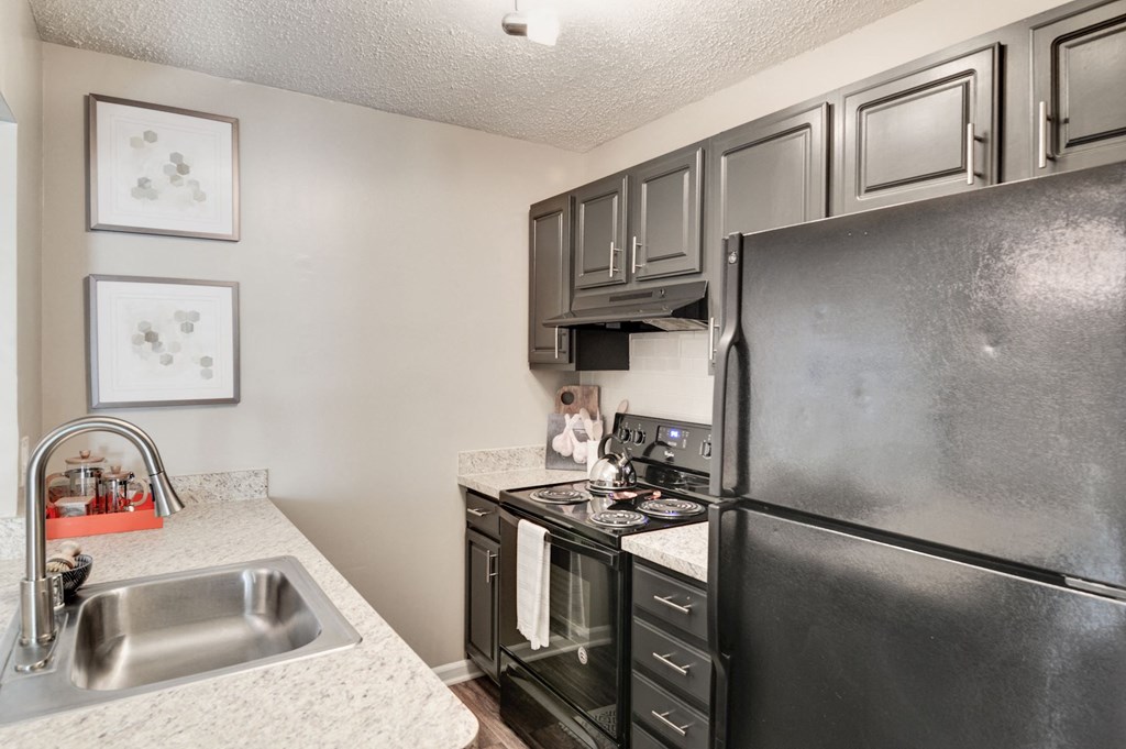 a kitchen with black appliances and white countertops at Hamilton at Kings Place, Columbia, 21046