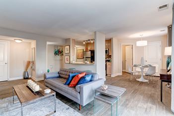 a living room with a couch table and chairs and a kitchen in the background at Ellicott Grove, Maryland, 21043