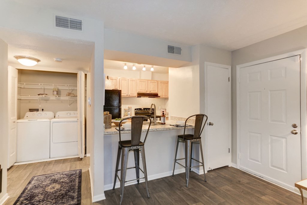 a kitchen with a breakfast bar and two stools at Madison at Eden Brook, Columbia, MD