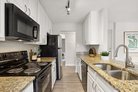 a kitchen with granite counter tops and black appliances