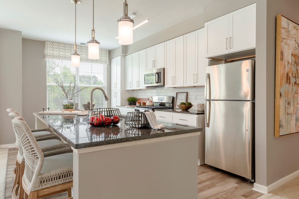 The Refinery kitchen with white cabinets and a granite countertop