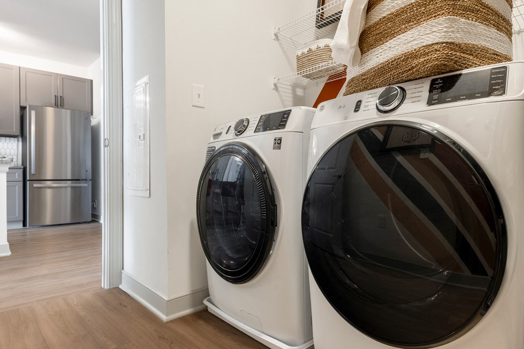 a washer and dryer in a laundry room with a stainless steel refrigerator