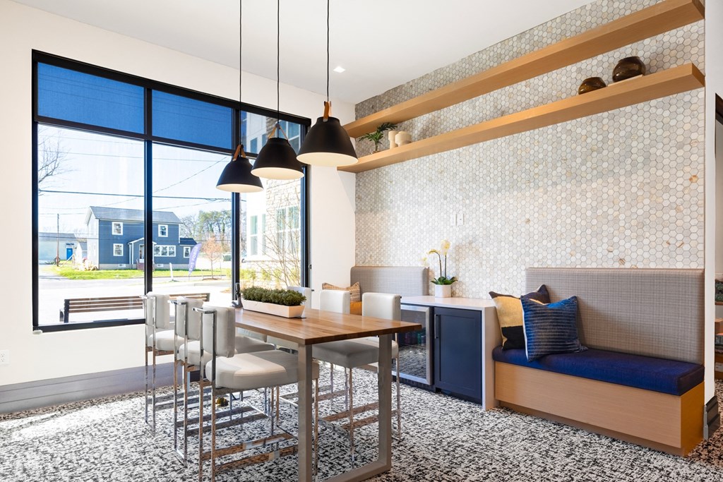 a dining room with a table and chairs and a large window