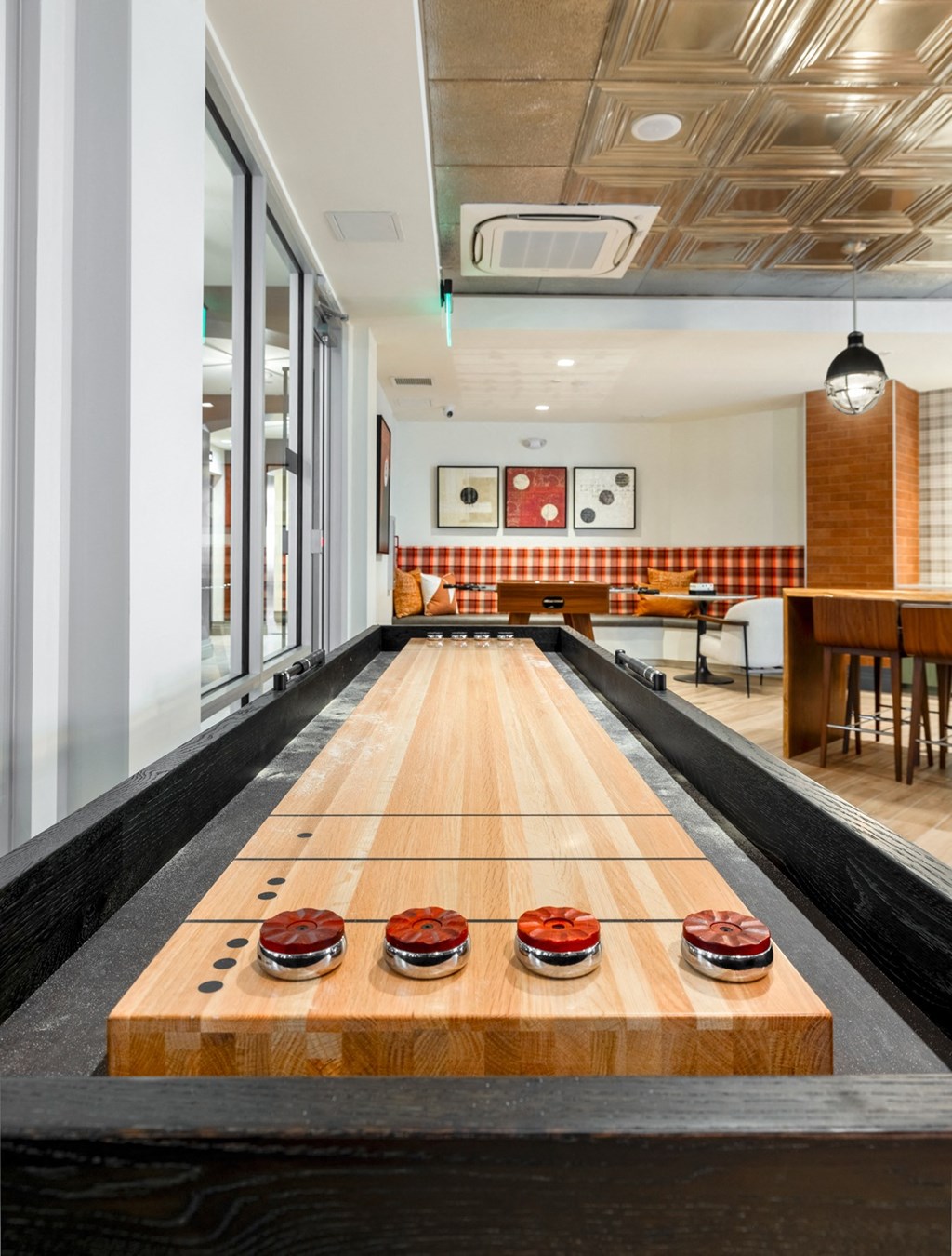 a bowling alley in the middle of a room with a table and chairs in the background