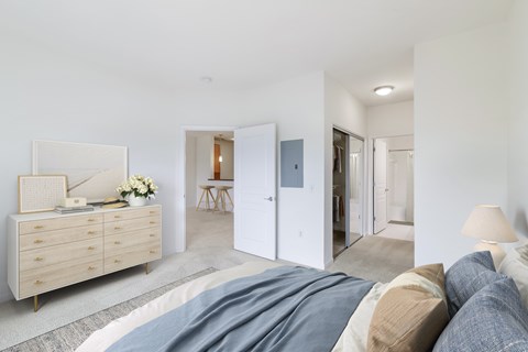 A bedroom with a bed, dresser, and mirror.