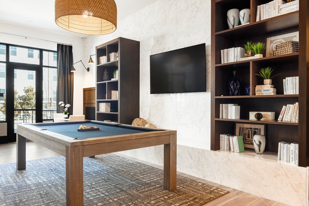 a living room with a pool table and a tv