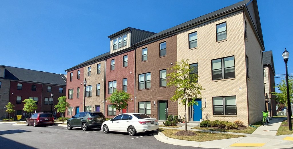 a brick apartment building with cars parked in front of it at Refinery Row, Baltimore, MD 21224