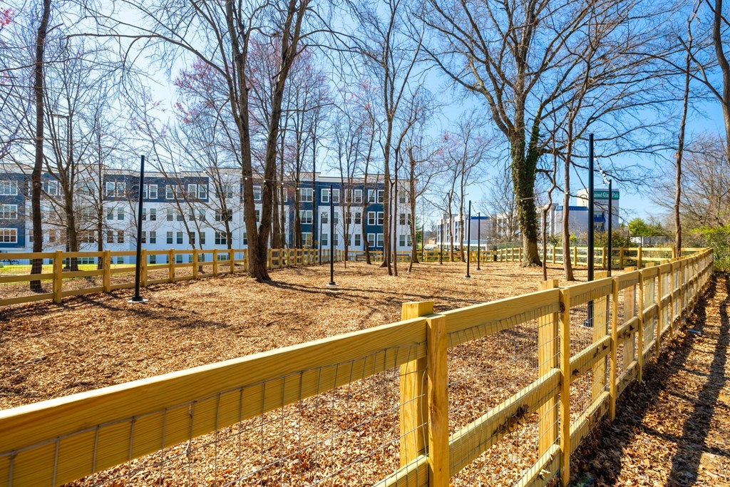 a yellow fence surrounds a park with trees and buildings