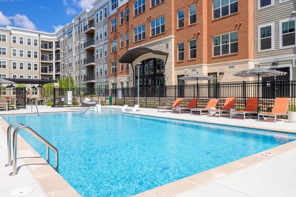a swimming pool with a red brick building in the background