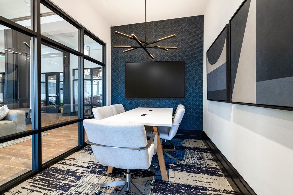 a conference room with a table and chairs and a tv