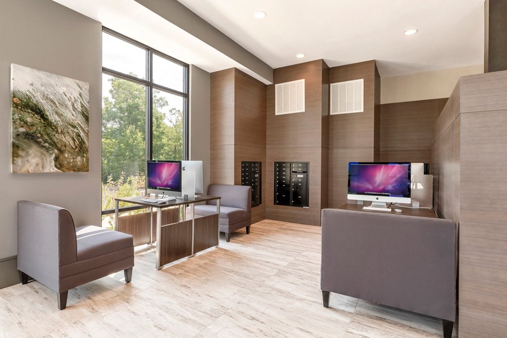 a reception area with two computers and chairs and a large window