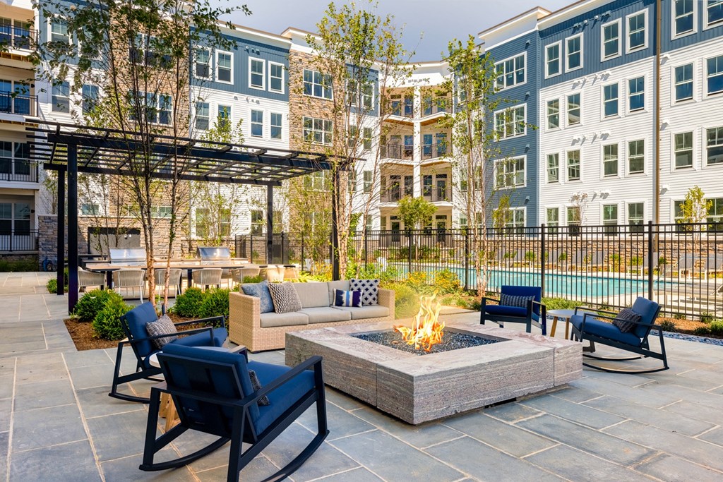 an outdoor patio with a fire pit and furniture at an apartment complex