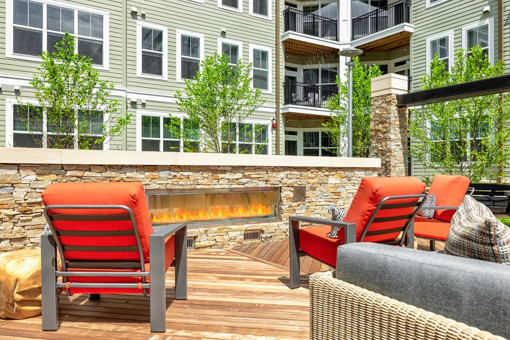a patio with a fireplace and a couch and chairs