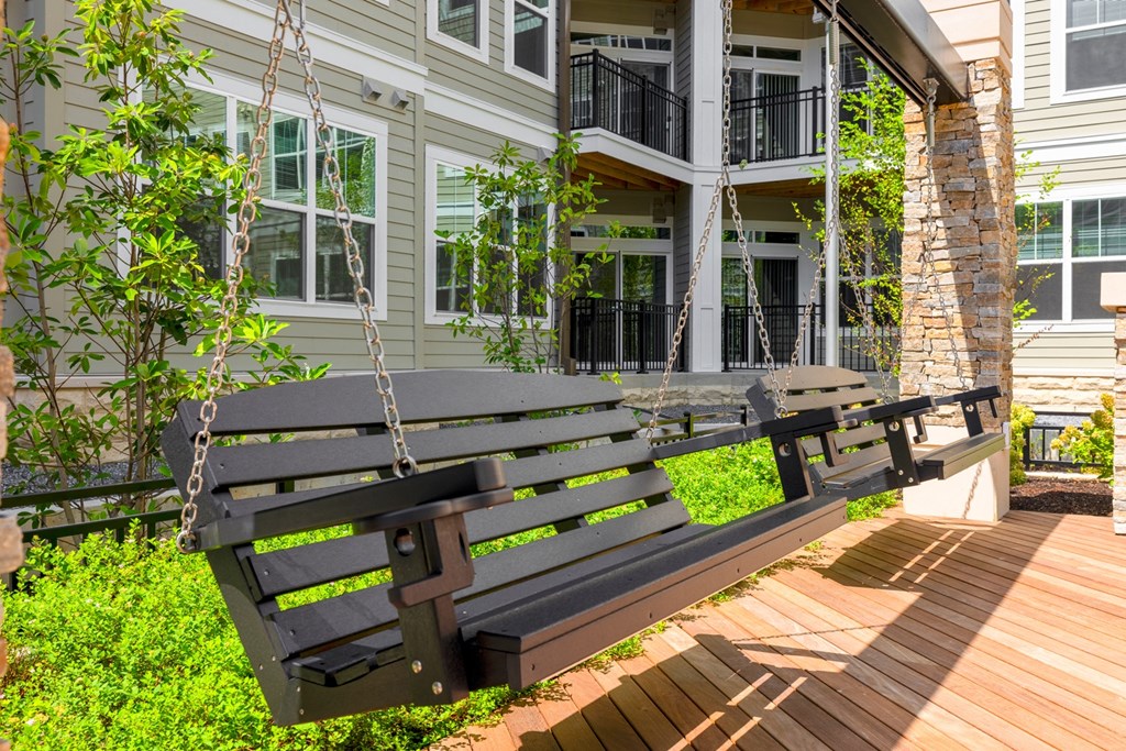 two benches on a wooden deck in front of a building