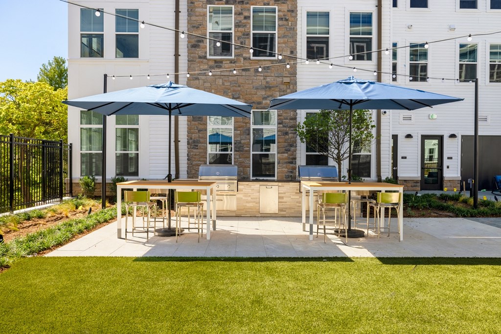 a patio with tables and umbrellas in front of a building
