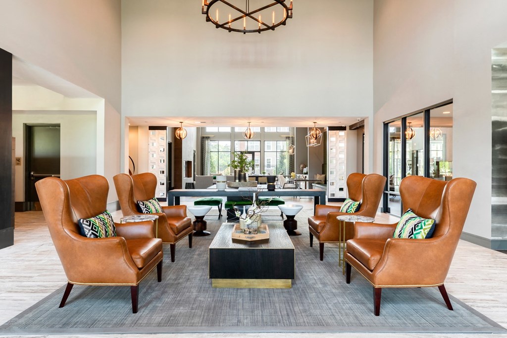 a living room with leather chairs and a coffee table