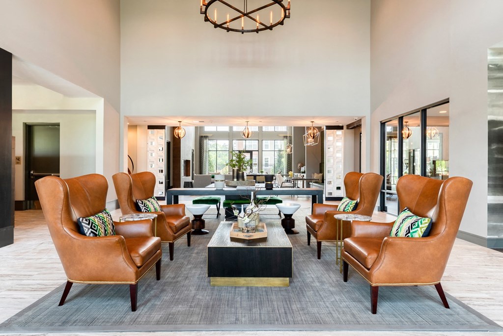 a living room with leather chairs and a coffee table