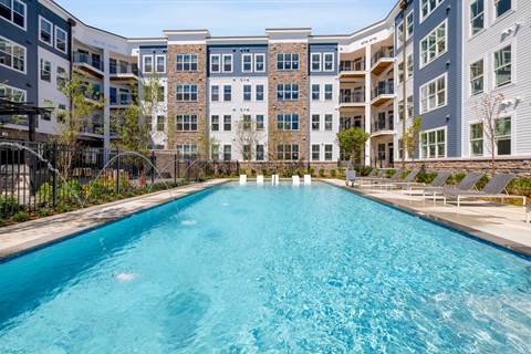a swimming pool with an apartment building in the background