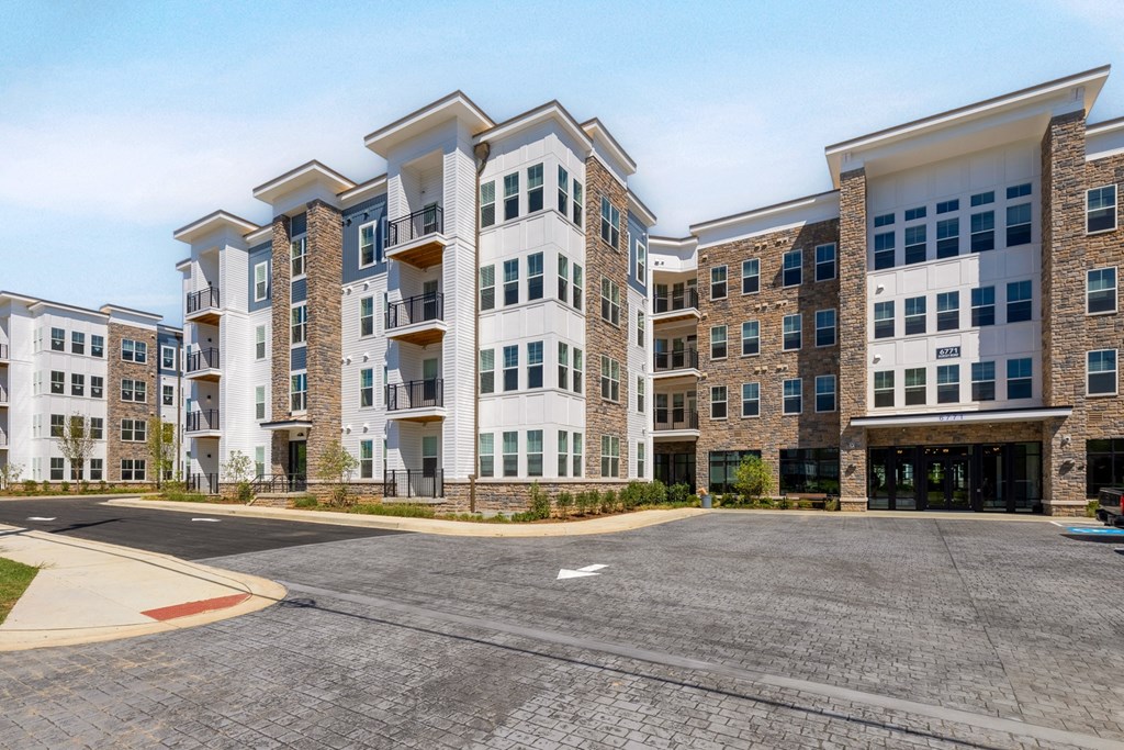 an empty parking lot in front of an apartment building