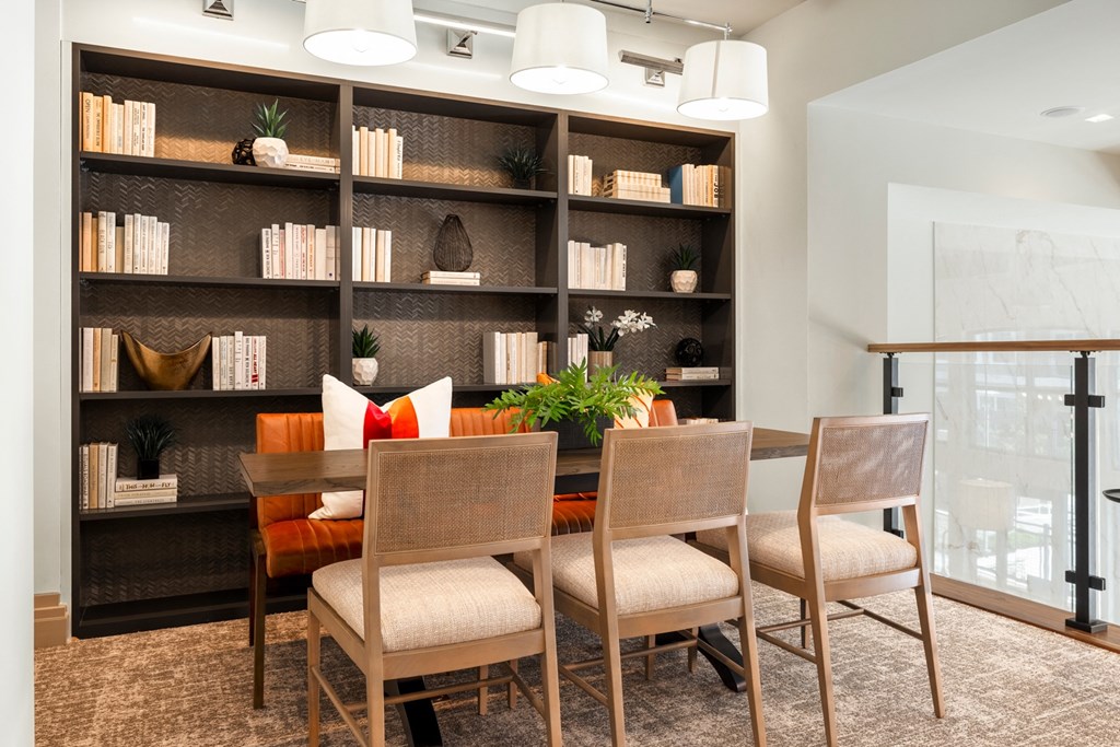 a dining room with a table and chairs in front of a bookshelf