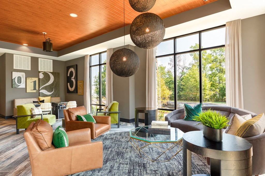 a living room with couches and chairs and large windows