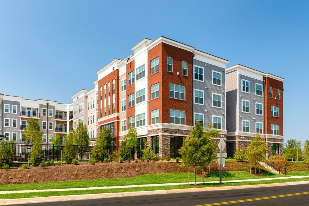 a large apartment building with a blue sky in the background