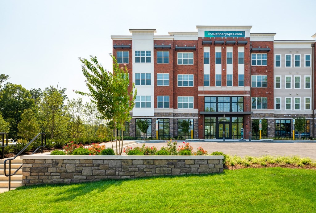 a large brick building with a green lawn in front of it