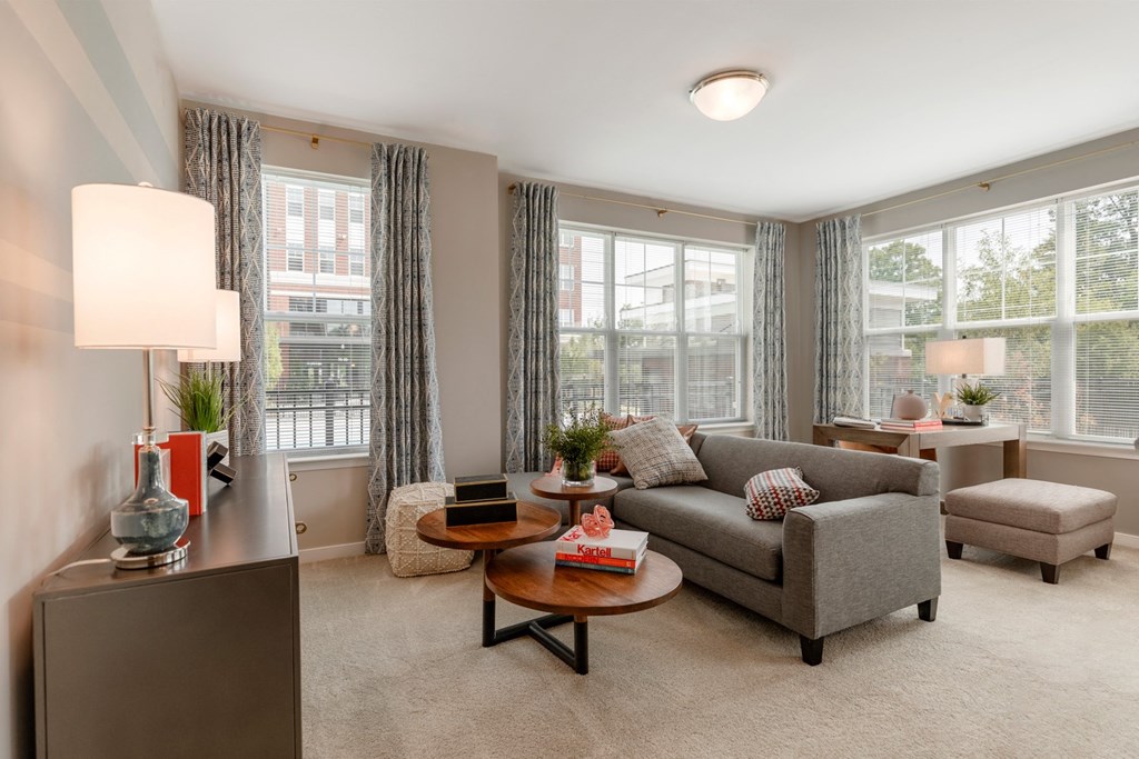 The Refinery living room with large windows and a gray couch
