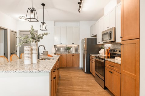 a kitchen with wooden cabinets and a marble counter top