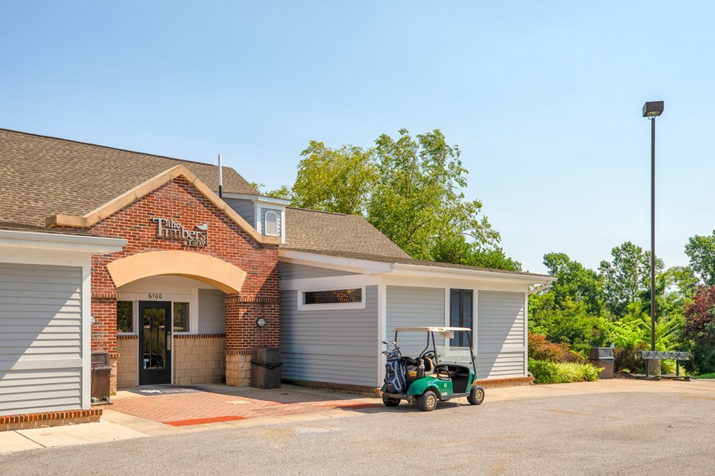 a golf club house with a golf cart parked in front of it