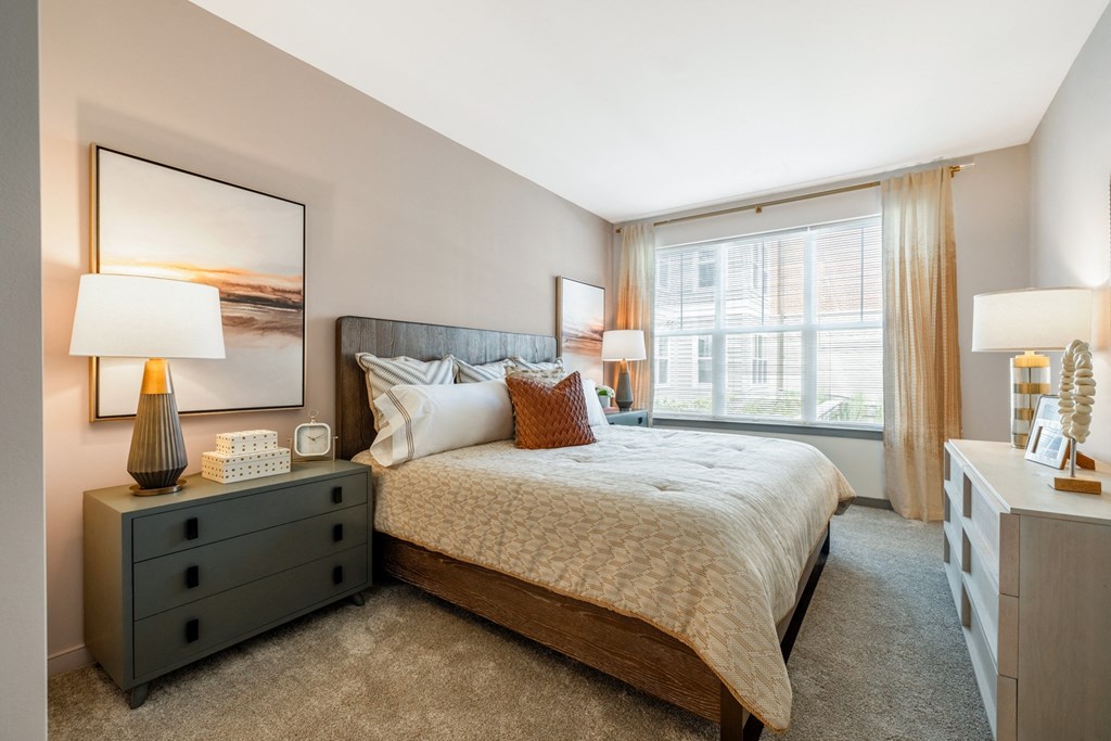 a bedroom with a large window and a large bed