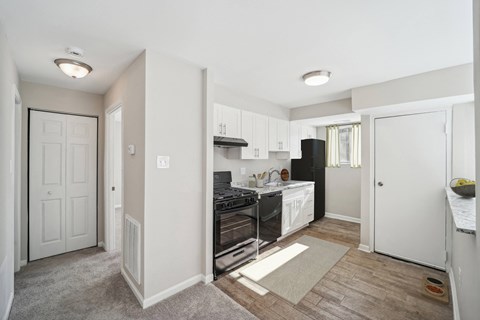 a renovated kitchen with white cabinets and a black stove