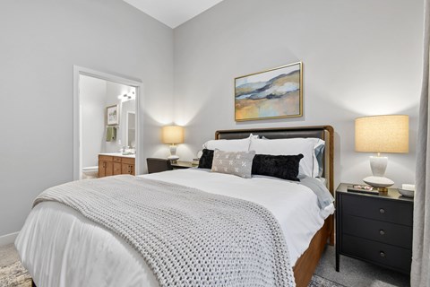 Bedroom with wood bed and ensuite bathroom at The Terrace Apartments, Frederick, Maryland