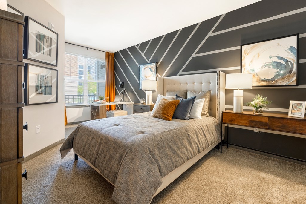 a bedroom with a bed and a desk in front of a window